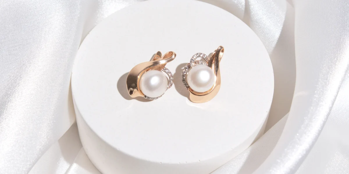 gold-earring-with-pearl-on-podium-2022-11-11-21-45-25-utc
